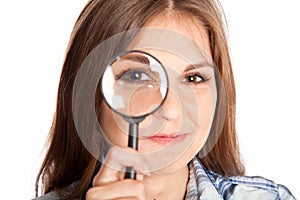 Girl is looking through magnifying glass