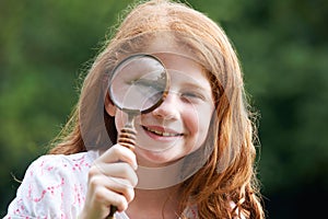 Girl Looking Through Magnifying Glass With Magnified Eye