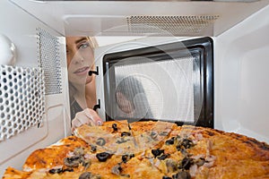 The girl looking in a microwave