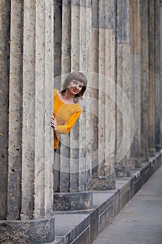 Girl looking out of old columns