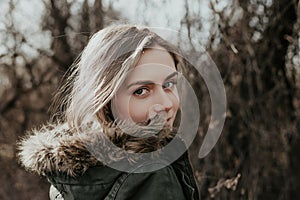 The girl is looking over her shoulder at camera in warm jacket