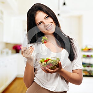 Girl looking positive and holding a bawl with salad photo