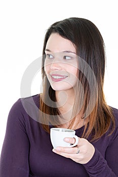 Girl is looking side and holding white cup in hands