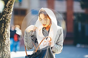 Girl looking for something in a bag