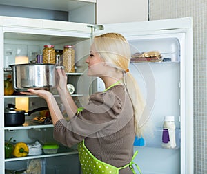 Girl looking for something in fridge