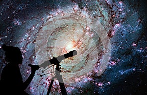 Girl looking at the stars with telescope. Messier 83