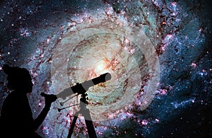 Girl looking at the stars with telescope. Messier 83 photo