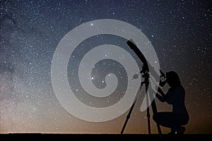 Girl looking at the stars with telescope. Milky Way galaxy.