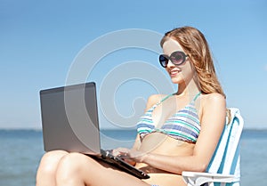 Girl looking at tablet pc on the beach