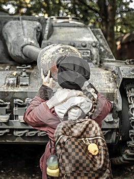 Girl looking into to barrel of old tank