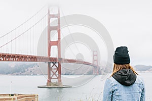 A girl looking towards Golden Gate Bridge in San Francisco, California.