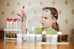Girl looks anxiously at test tube