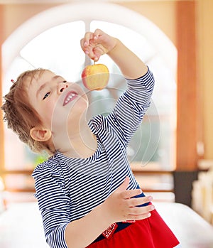 The girl looks at the apple