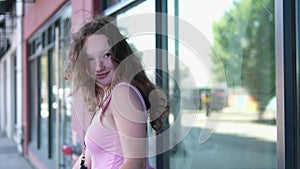 The girl looks back Canada Vancouver Wind blows smiling young woman In city center, young girl in pink dress walks in