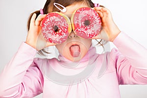 Girl looks through donuts