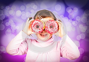 Girl looks through donuts