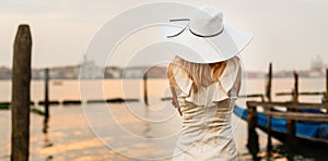 Girl looks at the gondola pier at dawn venice