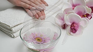 Girl looks at manicure on flower background