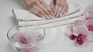 Girl looks at manicure on flower background