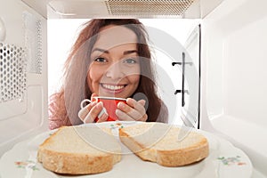 Girl looks in a microwave