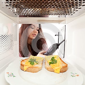 Girl looks in a microwave