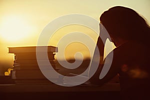 Girl with a lot of books on sunset background. Preparation for university exams. education concept