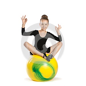 Girl in the lotus position on a big yellow balloon