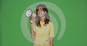 Girl with loudspeaker. Young woman shout in megaphone on chroma key green background. Advertising, promotion concept