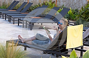 Girl on a lounger with a cocktail in sunglasses