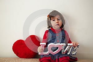 Girl with love sign and red plush heart