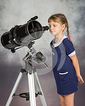 Girl lover of astronomy with interest looks in the eyepiece of the telescope