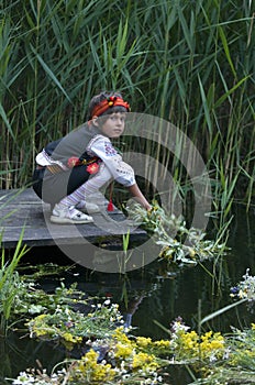 Girl lowers wreath on water - traditions of Ivan Kupala holiday