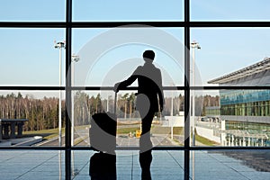 Girl with luggage standing in airport