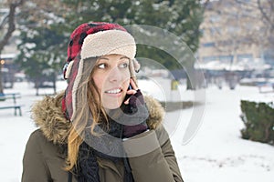 Girl with a lumberjack hat talking on her cellphone