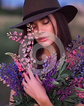 Girl with lupins in a lilac dress portrait