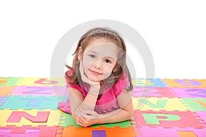 Girl lying on alphabet mat