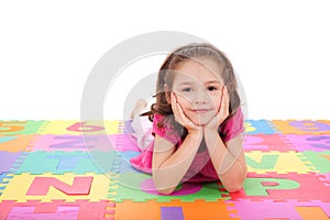 Girl lying on alphabet mat