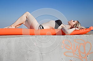 Girl lying on back on inflatable raft with eyes closed photo