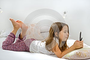 Girl lying on bed with cell phone