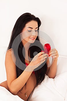 Girl lying in bed with gifts, heart, jewelry