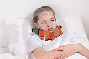 girl lying in bed, measuring body temperature with thermometer