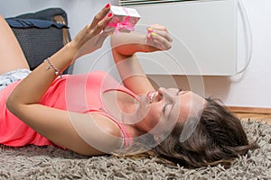 Girl lying on the carpet with present box