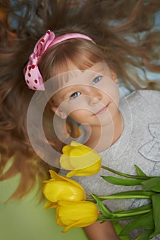 Girl lying on the floor with tulips as a present for mother