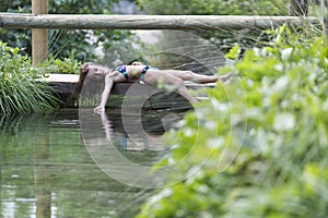 Girl lying on the footbridge of a lake. photo