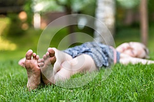 Girl lying on the grass, feet on foreground