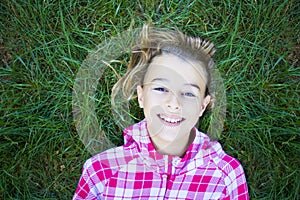 Girl lying on grass looking at camera