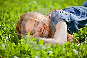 Girl lying on the grass and sleeping peacefully
