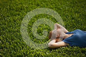 Girl lying on the grass and sleeping peacefully