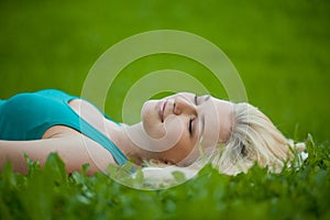 Girl lying on the grass and sleeping peacefully