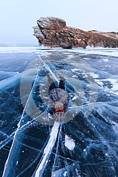 Girl lying on the ice on the island Ogoy on Lake Baikal